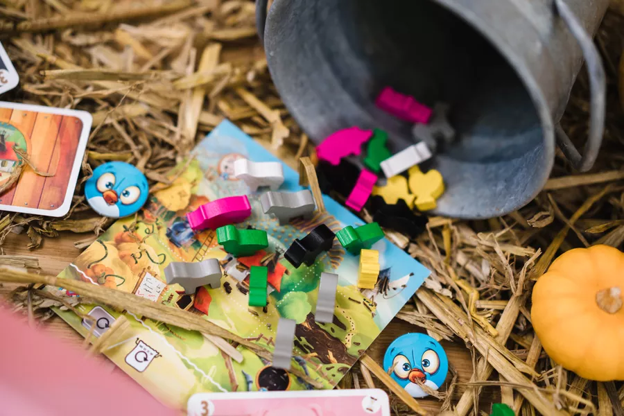 金属小桶倾倒在草垛中，五颜六色的动物木块像盲盒一样洒落，暗示着这片农场里不受控制的随机命运。