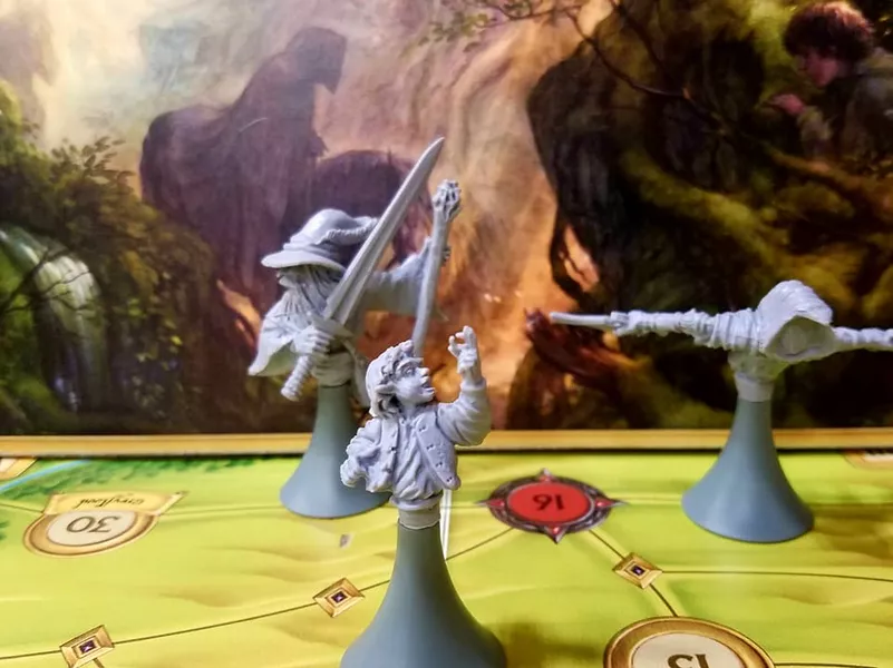 《搜寻魔戒》棋子与游戏板，背景有游戏盒